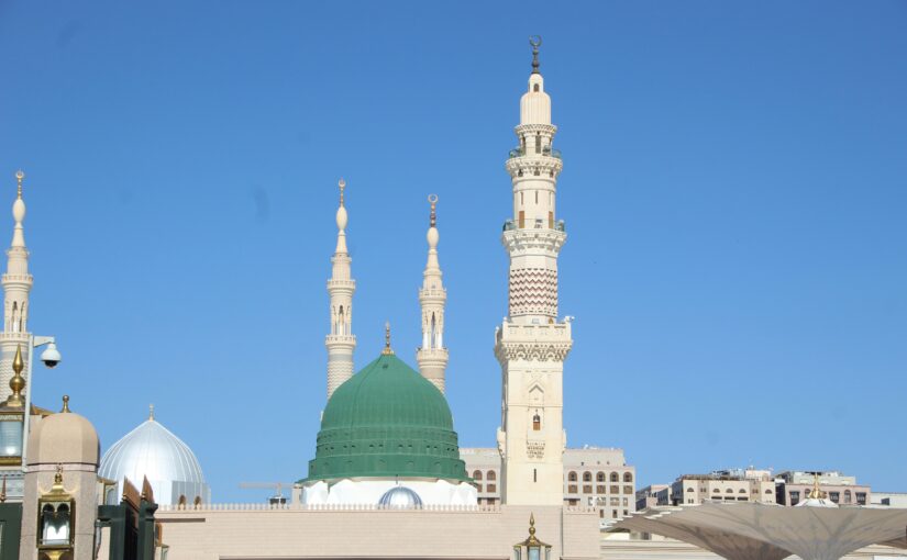 Beautiful mosque with green dome and tall minarets under blue sky representing Islamic spirituality for Shan-e-Mustafa naat